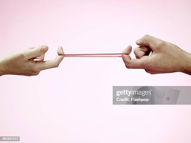 hands pulling rubber band - pulling stock pictures, royalty-free photos & images