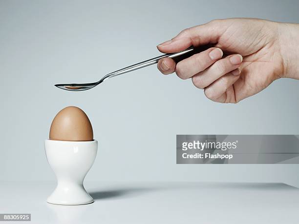 hand with spoon and soft-boiled egg - gekochtes ei stock-fotos und bilder