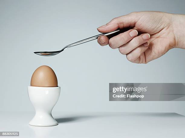 hand with spoon and soft-boiled egg - hard boiled eggs stock pictures, royalty-free photos & images