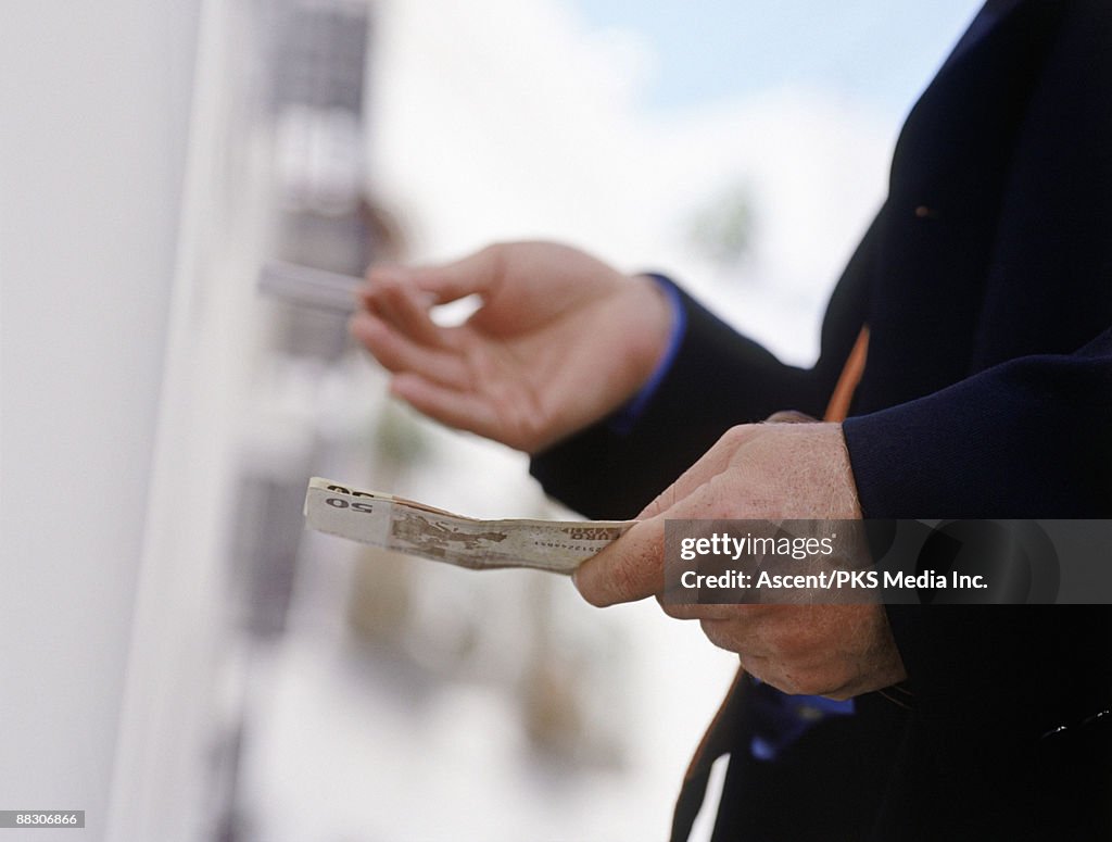 Man with money at ATM