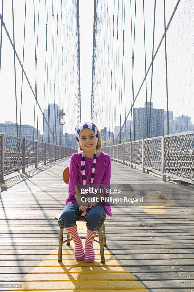 Girl sitting on bridge