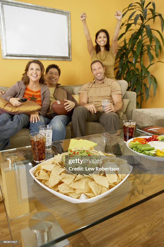 Excited friends watching television together