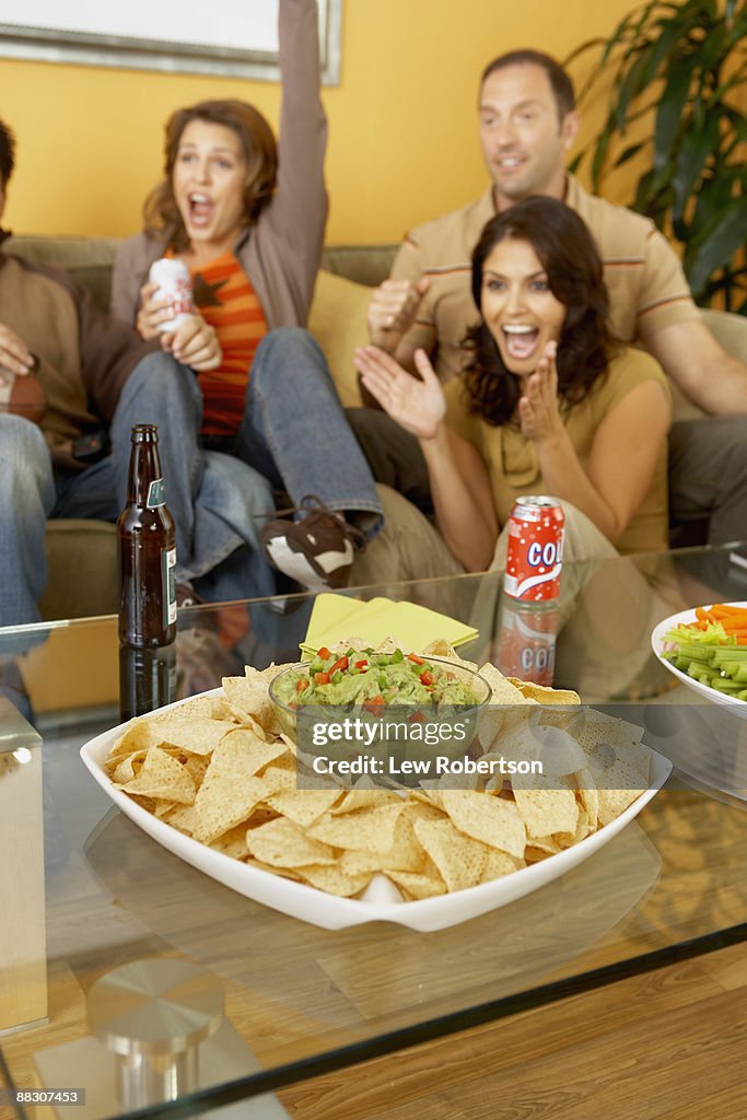Excited friends watching television together