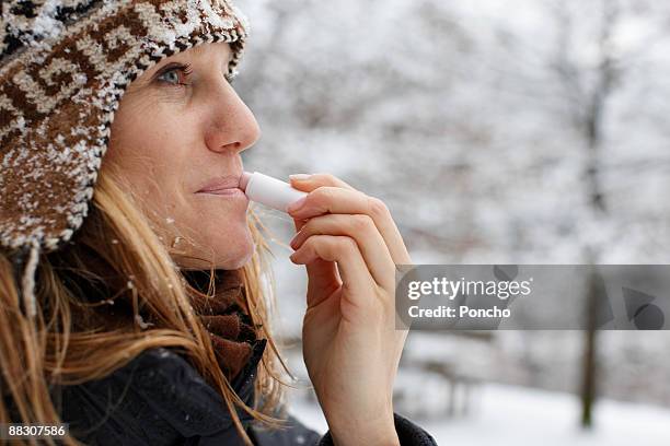 woman using lip balm - lip balm stock-fotos und bilder