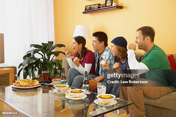 excited friends watching television together - chili woman ストックフォトと画像