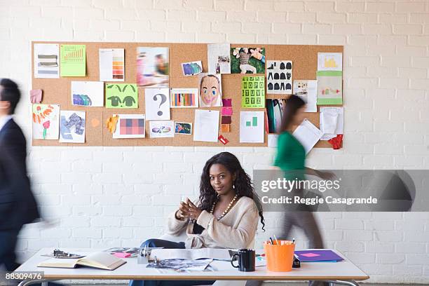 calm businesswoman in busy office - tablón de anuncios fotografías e imágenes de stock