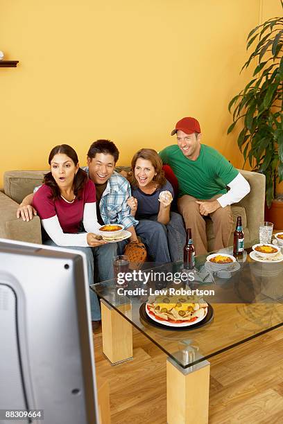 shocked friends watching television together - chili woman ストックフォトと画像