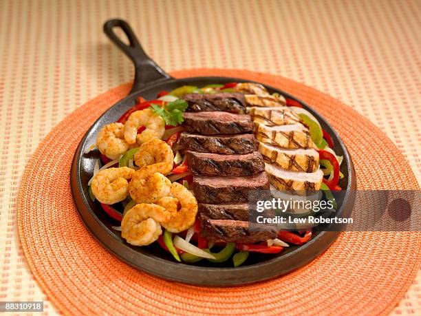 shrimp , beef and chicken in griddle - fajitas stock pictures, royalty-free photos & images