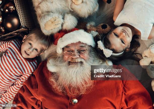 meisje, jongen en santa liggen op de vloer - santa claus lying stockfoto's en -beelden