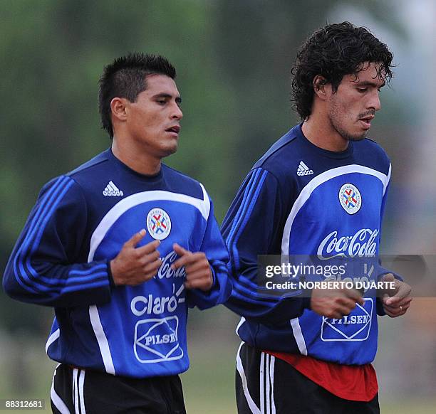 Paraguayan footballers Osvaldo Martinez and Cristian Riveros jog during a training session on June 8, 2009 in Ypane. Paraguay will meet Brazil next...