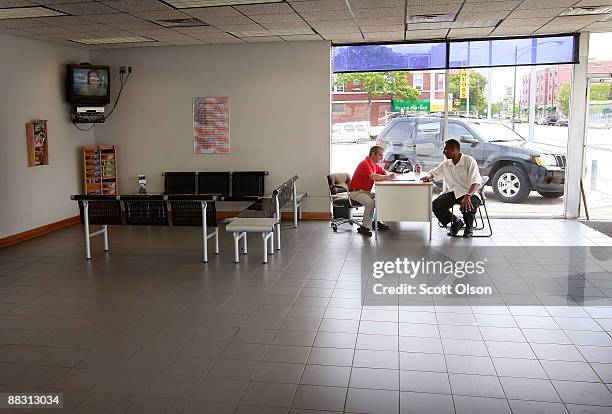 In the empty showroom at Premier Chrysler salesman Sam Zayed helps customer Jeffrey Turner as he shops for a Jeep June 8, 2009 in Chicago, Illinois....