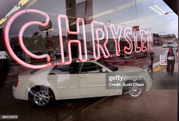 Neon sign shines out the showroom window of Balzekas Chrysler dealership June 8, 2009 in Chicago, Illinois. The dealership, which has been in...