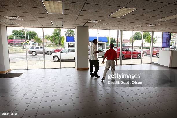 In the empty showroom at Premier Chrysler salesman Sam Zayed helps customer Jeffrey Turner as he shops for a Jeep June 8, 2009 in Chicago, Illinois....