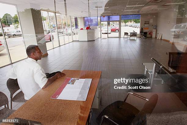 In the empty showroom at Premier Chrysler Jeffrey Turner waits to hear back from the salesman as he tries to work a deal on a new Jeep June 8, 2009...