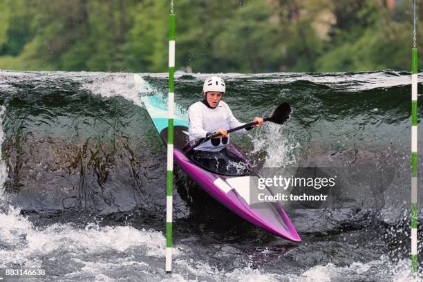 front view of young female kayaker reaching the green gate during the race - swift river stock pictures, royalty-free photos & images