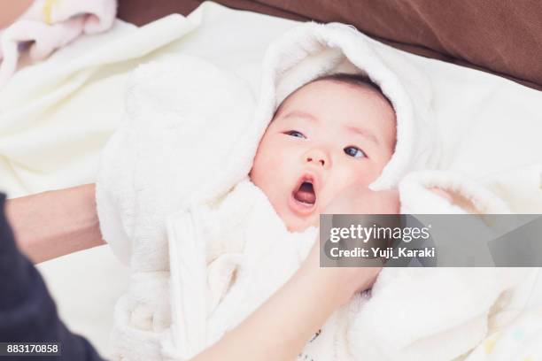 pasgeboren baby in een pluizige witte badjas tikte omhoog door moeder - bath robe stockfoto's en -beelden