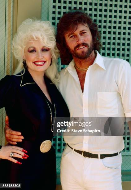 Portrait of American musician & actress Dolly Parton and British musician Barry Gibb, of the Bee Gees, as they pose together at Kenny Rogers' home,...