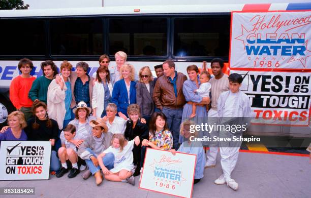 Portrait of a large group of celebrities as they poses in front of the Hollywood Clean Water Caravan bus, California, 1986. Among those pictured are,...