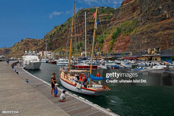 Segelyacht bereit zum Auslaufen im Fischer- und Yachthafen von Calheta, im Hintergrund: Hotel Calheta Beach, Calheta, Madeira, Portugal