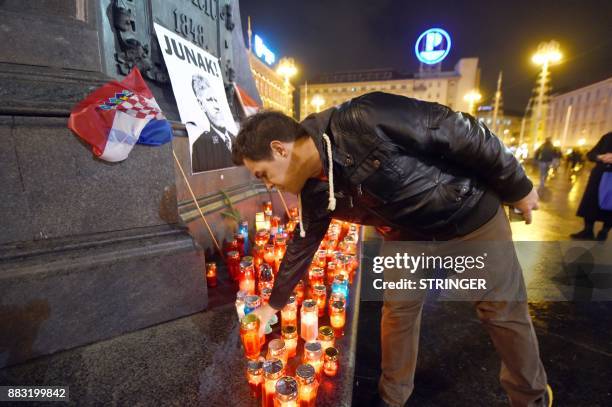 Man places a candle in tribute to General Slobodan Praljak in Zagreb on November 30 after the Bosnian Croat war criminal took his own life in front...