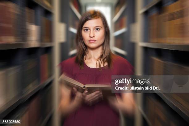 Studentin mit Buch in Bibliothek