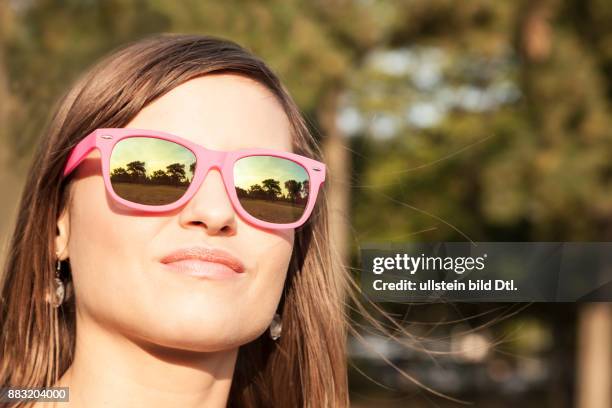 Junge Frau mit pinker Sonnenbrille