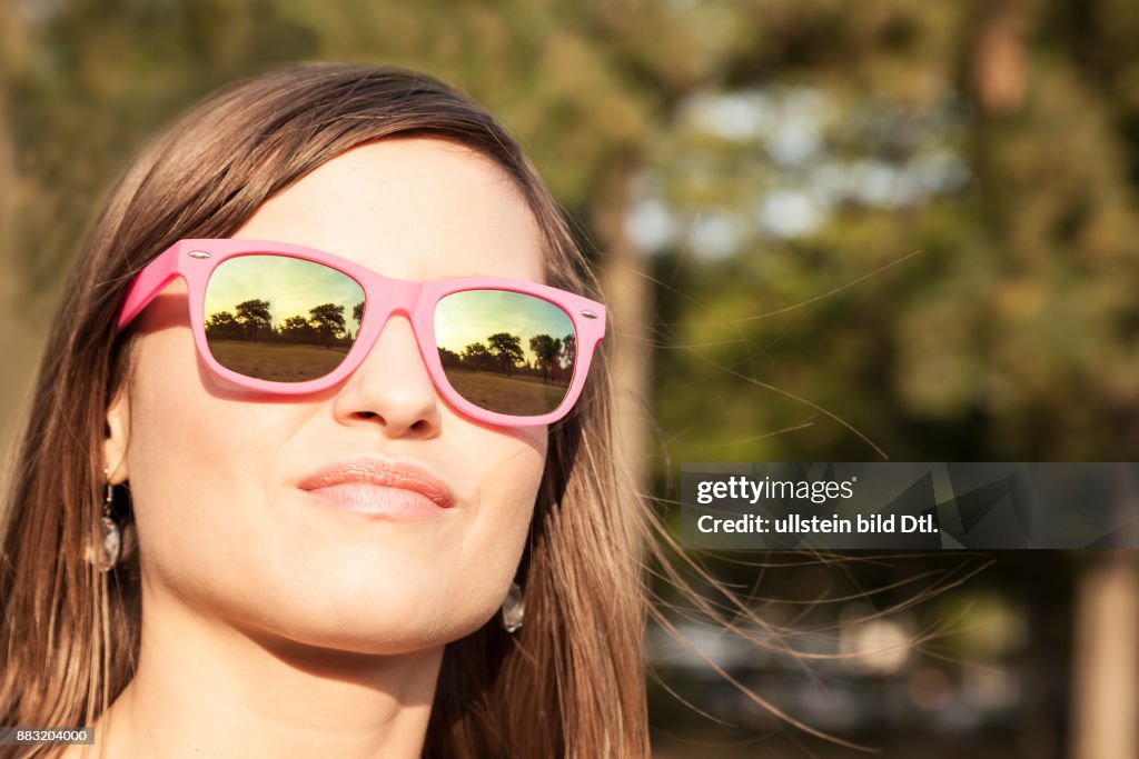 Junge Frau mit pinker Sonnenbrille