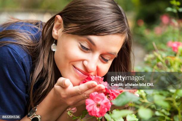 Hübsche Frau duftet an Blume