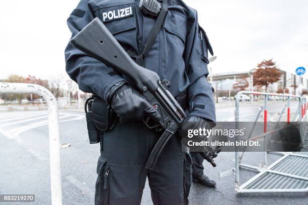 Polizist mit Maschinengewehr sperrt den Sicherheitsbereich beim Bundeskanzleramt während des Obama Besuchs ab