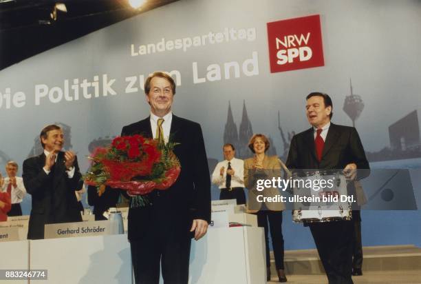 Landesparteitag der SPD Nordrhein-Westfalen in Bochum: Gerhard Schröder mit einer Trommel in den Händen, auf der NRW SPD gedruckt ist, gratuliert...