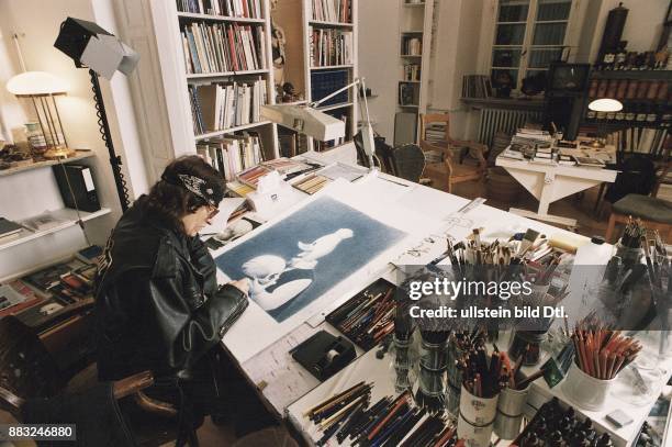 Der Maler Gottfried Helnwein sitzt in seinem Atelier auf Burg Brohl am Rhein an einem großen Tisch und zeichnet. Auf dem Bild ist Donald Duck...