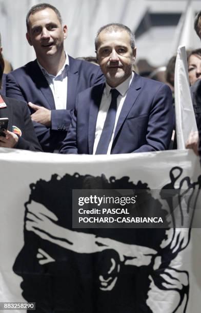 Pe a Corsica nationalist party candidates for Corsican regional elections Gilles Simeoni and Jean-Guy Talamoni stand behind a Corsican flag during a...