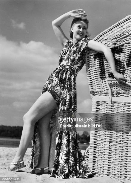 Ein Model präsentiert ein buntes Sommerkleid mit Blumenmuster am Strand Aufnahme: Sonja Georgi Originalaufnahme im Archiv von ullstein bild