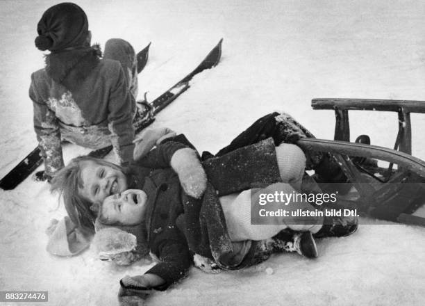 Rodeln: Kinder mit Schlitten und auf Skiern haben Spaß im Schnee Aufnahme: Hanns Hubmann Originalaufnahme im Archiv von ullstein bild