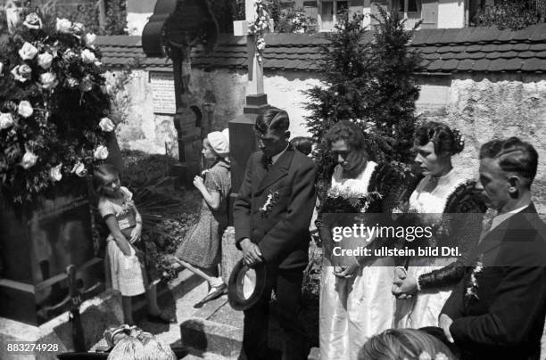 Nach dem Verlassen der Kirche beten die Brautpaare am Grab der Vorfahren Aufnahme: Hanns Hubmann Originalaufnahme im Archiv von ullstein bild