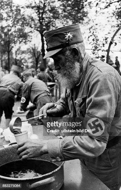 Ein älterer Mann als Kamerad beim Dienst, schenkt Tee aus Aufnahme: Hanns Hubmann Originalaufnahme im Archiv von ullstein bild