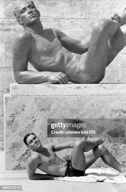 Olympische Sommerspiele 1936/ Schwimmen: Der australische Schwimmer Bill Kendall in einer lustigen Pose an einer männlichen Skulptur Aufnahme: Hanns...