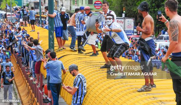 Supporters of Brazils Gremio footballers cheer their team upon its arrival after winning the Copa Libertadores 2017, on November 30 in Porto Alegre,...