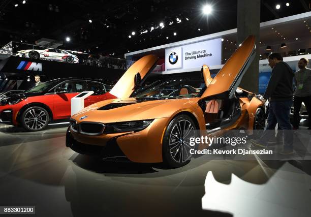Attendees look at the BMW i8 Roadster during the auto trade show AutoMobility LA at the Los Angeles Convention Center November 30 in Los Angeles,...