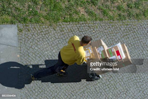 Berlin, Paketzusteller DHL mit voll beladener Paketkarre auch mit einem Paket von Amazon, Blick von oben, DHL Paket und Express sind ein Teil des...