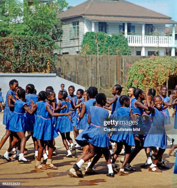 Afrikanische Schulkinder, Maedchen, in einer Hofpause in Freetown, sie alle tragen einheitliche Schulkleidung, um soziale Unterschiede ihrer...