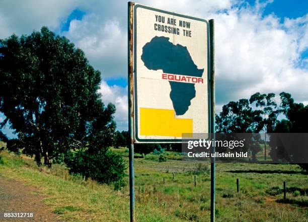 Hinweisschild im Hochland in Kenia zum Verlauf der Aequatorebene, dem groessten Breitenkreis, der die Erde in eine Nord- und Suedhalbkugel teilt,...