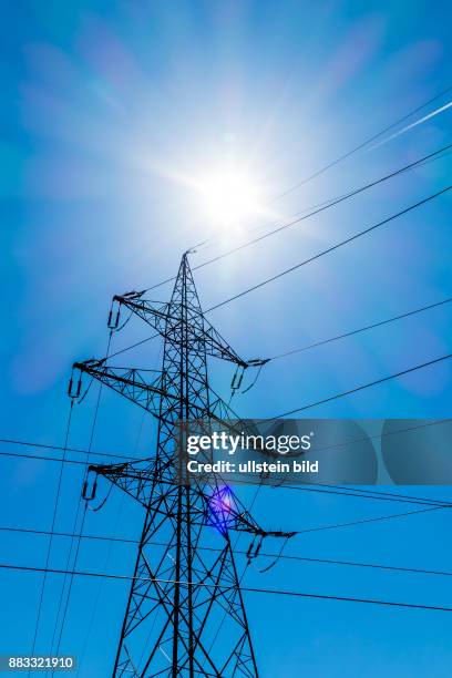 Der Strommast einer Hochspannungsleitung. Symbolfoto für Energie. Vor blauem Himmel