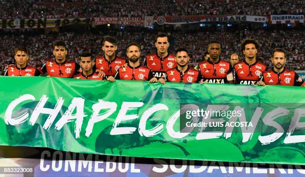 Players of Brazilian team Flamengo pose for pictures behind a banner with the name of Brazilian club Chapecoense, before the start of their Copa...