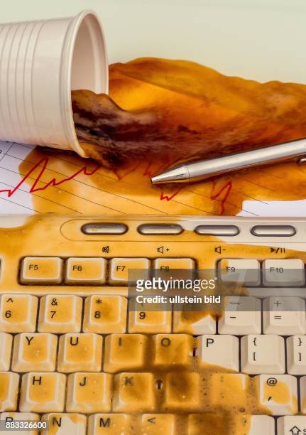 In einem Büro wird durch ein Missgeschick ein Becher mit Kaffee auf einen Computer verschüttet