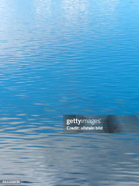 Himmel und Wolken spiegeln sich in einem See.