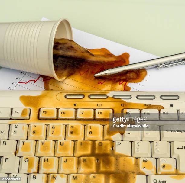 In einem Büro wird durch ein Missgeschick ein Becher mit Kaffee auf einen Computer verschüttet