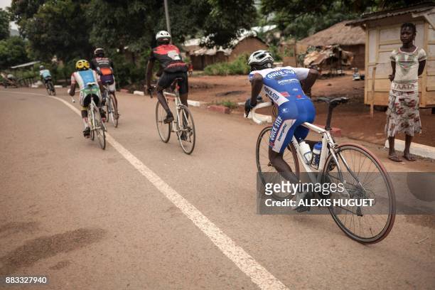 Bangui's cycling team crosses the Ngaragba district during a weekly training session in Bangui on October 26, 2017. - The country is chronically...