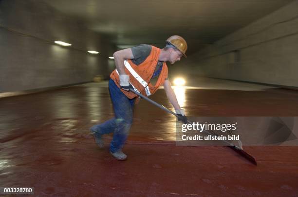 Deutschland Germany / Berlin; Baustelle Sanierung im Autobahntunnel A 111 Tunnel Flughafen Tegel, Bauarbeiter bringen eine Grundierungsmasse auf -