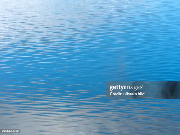 Himmel und Wolken spiegeln sich in einem See.